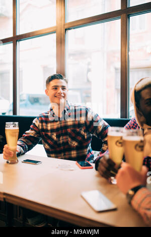 Männer trinken Bier und Talk im pub Stockfoto