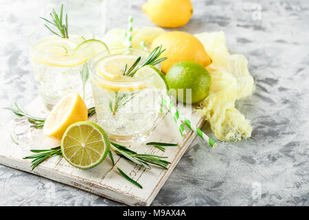 Kalte Limonade oder alkoholfreien Cocktail mit Zitrone, Rosmarin und Eis im Glas Gläser auf einem hellen Hintergrund Stockfoto