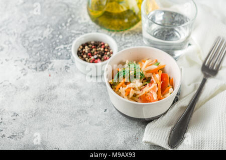 Kohl Salat mit Möhren, Tomaten und Gurken in einem kleinen Pialen auf einem Leuchttisch. Traditionelle Krautsalat Stockfoto