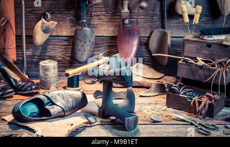 Vintage Schuhmacherwerkstatt mit Werkzeugen und Schuhe Stockfoto