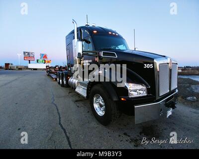 Beifahrerseite Nahaufnahme einer2019 schwarz Kenworth T880 Semi Truck, zu einem RGN lowboy Trailer festgehakt Stockfoto