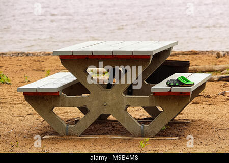 Vergessen Schuhe an einem Picknicktisch am Strand Stockfoto