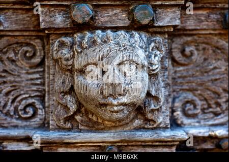 Holzschnitzerei von Gesichtern auf mittelalterlichen Türen Stockfoto