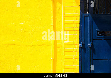 Gelbe Wand und blau Metall Hintergrund Stockfoto