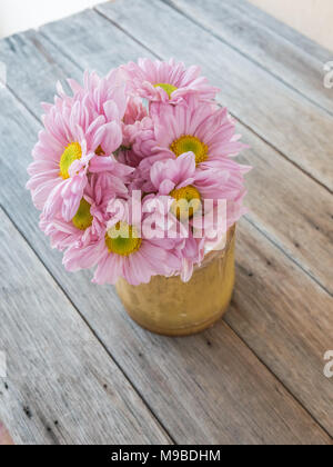 Rosa Blume in der Vase aus Bambus auf Holztisch, Stockfoto