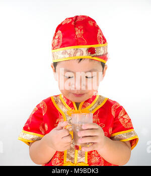 Little Boy trug das chinesische Neujahr Anzug im Studio und Schokolade Milch an Hand, Isolieren, weißer Hintergrund, Stockfoto