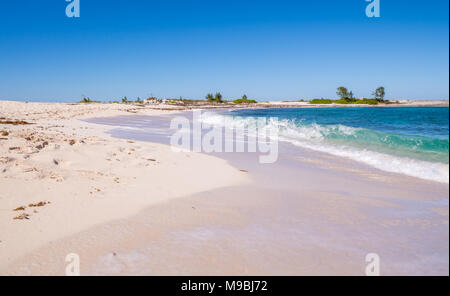 Pink Sand Beach Bahamas auf Ebbe mit Strand mit flauschigen rosa Sand, klares türkises grünes Wasser an einem sonnigen Tag mit hoher Kontrast Himmel Stockfoto