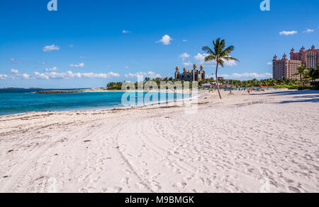 Pink Sand Beach Bahamas auf Ebbe mit Strand mit flauschigen rosa Sand, klares türkises grünes Wasser an einem sonnigen Tag mit hoher Kontrast Himmel Stockfoto