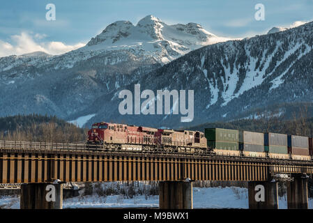 Hlw-loco9351 führt intermodalen Zug im Winter durch Holz- Schnee Schuppen entlang drei Valley Lake BC Stockfoto