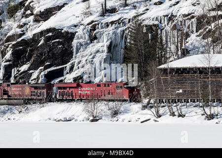 Hlw-Lok 8640 schiebt Kohlenzug eastbound Vergangenheit Rogers Pass Gletscher Station in fallenden Schnee BC Stockfoto