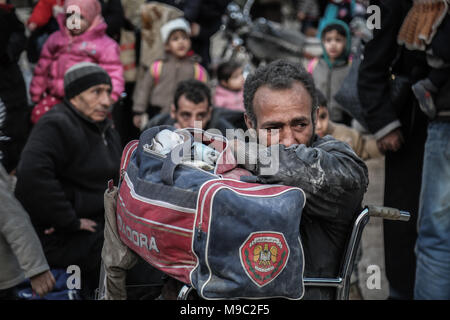 Zivilisten warten von der östlichen Provinz Syrien Al-Ghouta außerhalb von Damaskus, Syrien, 24. März 2018 evakuiert werden. Östlichen Al-Ghoutha war Syrien Rebellen hochburg aber Anti-Regime Kämpfer legte die Arme nach einem Deal ausgehandelt wurde, die Soldaten und ihre Angehörigen eine sichere Passage nach Norden Syriens garantiert. Foto:: Anas Alkharboutli/dpa Stockfoto