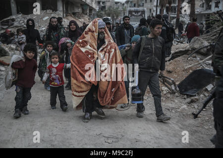 Zivilisten warten von der östlichen Provinz Syrien Al-Ghouta außerhalb von Damaskus, Syrien, 24. März 2018 evakuiert werden. Östlichen Al-Ghoutha war Syrien Rebellen hochburg aber Anti-Regime Kämpfer legte die Arme nach einem Deal ausgehandelt wurde, die Soldaten und ihre Angehörigen eine sichere Passage nach Norden Syriens garantiert. Foto:: Anas Alkharboutli/dpa Stockfoto