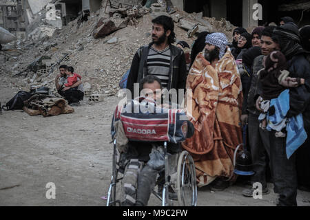 Zivilisten warten von der östlichen Provinz Syrien Al-Ghouta außerhalb von Damaskus, Syrien, 24. März 2018 evakuiert werden. Östlichen Al-Ghoutha war Syrien Rebellen hochburg aber Anti-Regime Kämpfer legte die Arme nach einem Deal ausgehandelt wurde, die Soldaten und ihre Angehörigen eine sichere Passage nach Norden Syriens garantiert. Foto:: Anas Alkharboutli/dpa Stockfoto