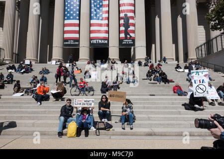 Washington, DC. 24. April 2018. Auf den Stufen des National Archives, ironische Banner oben, einige Der hunndreds von tausenden Demonstranten eine Pause während der massiven Rallye auf der Pennsylvania Ave. verlangen, dass die Sicherheit und das Ende der Waffengewalt eine Priorität ist, und protestieren Regierung Untätigkeit auf Gewehr die Kontrolle zu übernehmen, und der Einfluss der National Rifle Association auf dem Kongress. Bob Korn/Alamy leben Nachrichten Stockfoto