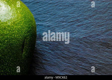 Volle grüne avocado Obst auf super Unscharf blaue Stein Hintergrund Oberfläche Stockfoto