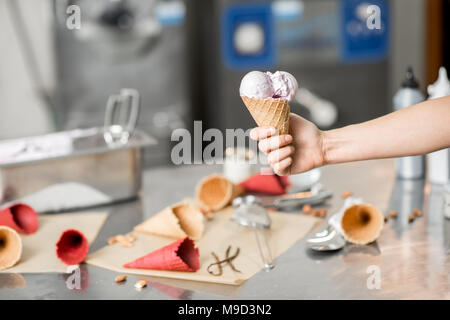 Holding Waffel Kegel mit Eis drinnen Stockfoto