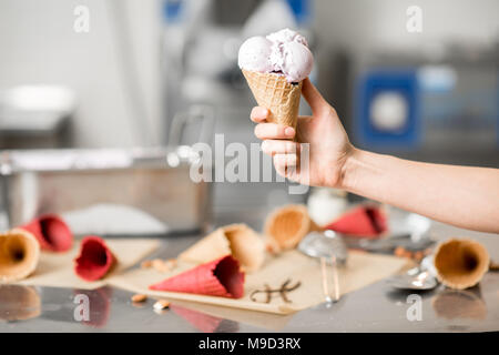 Holding Waffel Kegel mit Eis drinnen Stockfoto