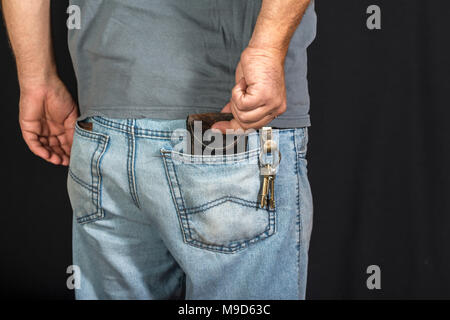 Des Menschen Hand unter Portemonnaie aus seiner eigenen Tasche Stockfoto