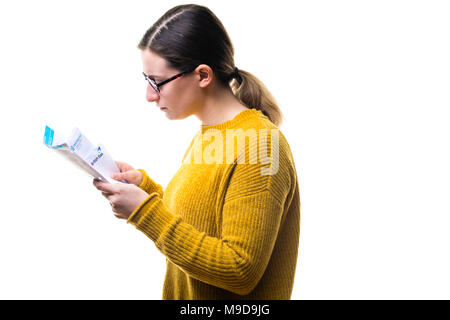 Geldsorgen und persönliche Finanzen: Eine Junge kaukasier Frau Mädchen mit einem gelben Pullover Pullover, an ihrer Rechnungen suchen und über das Zahlen von inländischen Stromversorgung Gebühren besorgt, Großbritannien Stockfoto