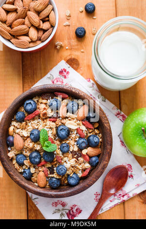 Müsli oder Müsli mit getrockneten Früchten und Nüssen in Houten, Ansicht von oben. Konzept der gesunden Lebensweise, Ernährung, Diäten, morgen und Frühstück Stockfoto