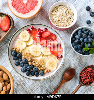 Acai smoothie Schüssel mit Bananen, Erdbeeren, Heidelbeeren und Müsli, Ansicht von oben, Quadrat crop. Gesunde Ernährung, gesunde Lebensweise, Diäten, Fitness Konz Stockfoto