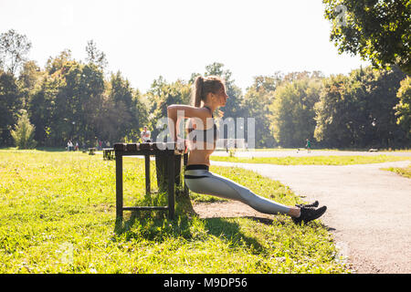 Fitness, Sport, Training, Ausbildung und Personen Konzept - Paar tun Trizeps dip-Übung auf city street Bank. Stockfoto