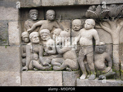 Alte Stein bas-relief mit einer Gruppe von Menschen - mens und Frauen, Buddhistischen Tempel Borobudur, Yogyakarta, Zentraljava, Indonesien. UNESCO-Welterbe Stockfoto