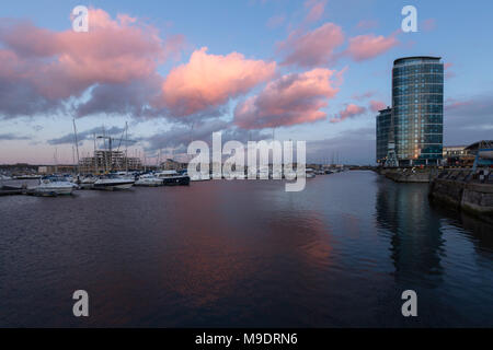 Große rosa Wolken im Wasser spiegelt kurz vor Sonnenuntergang über Chatham Maritime Marina, Chatham Werft am Fluss Medway, Kent, Großbritannien Stockfoto