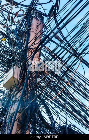 Riesige unordentlich Gewirr von Dutzenden von elektrischen Kabeln an der Spitze einer Strommast, Kambodscha Stockfoto