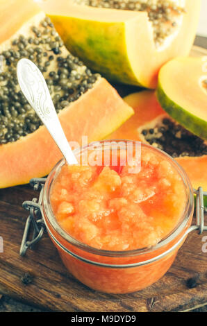 Frischer papaya natürliche Gesichtsmaske peeling Pürees in Glas Glas mit Löffel auf Holz- Hintergrund. Hautpflege und Wellness vitamin Antioxidans kosmetische conce Stockfoto