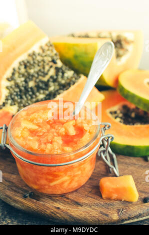 Frischer papaya natürliche Gesichtsmaske peeling Pürees in Glas Glas mit Löffel auf Holz- Hintergrund. Hautpflege und Wellness vitamin Antioxidans kosmetische conce Stockfoto