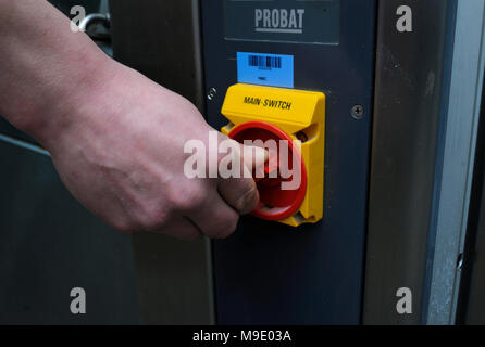 In der Bäckerei: Bäcker hand drehen einen Schalter auf dem Bedienfeld eines elektrischen Backofen. März 21, 2018. Brovary, Ukraine Stockfoto