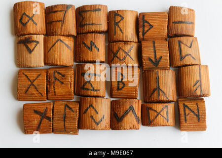 Holz- Runen liegen auf einem Tisch auf weißem Hintergrund Stockfoto