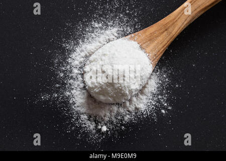 Natron auf einer hölzernen Löffel auf dunklem Hintergrund, Ansicht von oben, Natriumbikarbonat, Pulver, Natur, Kochen, Backen, Stockfoto