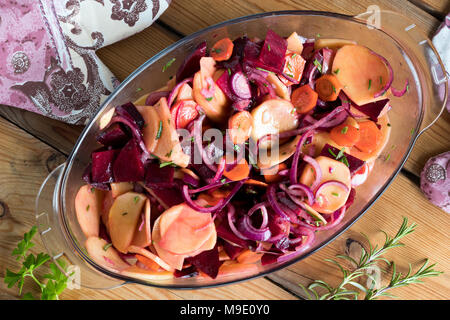 Geschnittenes Gemüse (Kartoffeln, rote Rüben, Karotten, rote Zwiebeln) in einem Glas Bräter auf eine Tabelle, Ansicht von oben Stockfoto