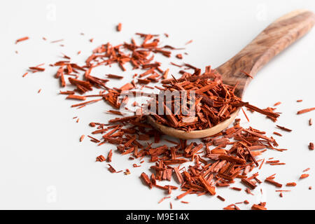 Stücke von Sandelholz auf einem Löffel aus Holz, auf einem weißen Hintergrund. Stockfoto