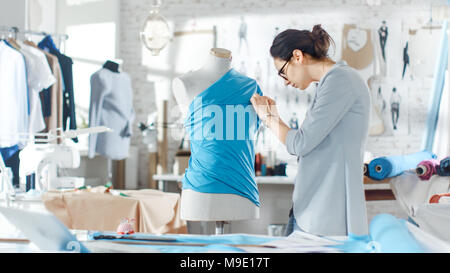 Schöne weibliche Mode, Designer, Einstellung der Gewebe auf eine maßgeschneiderte Schaufensterpuppe. In ihrem Atelier verschiedene Nähen und farbenfrohen Stoffen zur Um Stockfoto