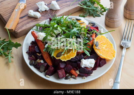 Salat gebackene Rote Beete und Karotten, Orangen, Rucola, Ziegenkäse, Gerösteter Kürbis- und Sonnenblumenkerne. Stockfoto