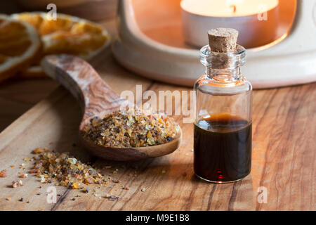 Eine Flasche Myrrhe ätherisches Öl Myrrhe Harz, mit einem Aroma Lampe im Hintergrund Stockfoto