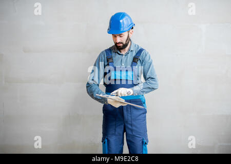 Gipser mit Spachtel innen Stockfoto
