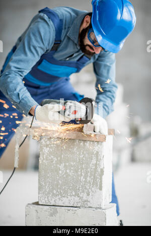 Builder Schneiden von Metall im Innenbereich Stockfoto