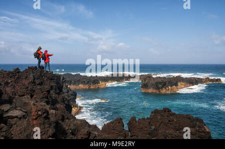 PONTA DE FERRARIA, POTUGAL - Mai 07, 2012: Zwei Touristen nehmen Foto meer Landschaften an der Küste von Sao Miguel, Azoren Stockfoto