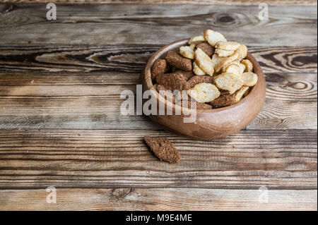 Roggen und Weizen Krümel in eine Schüssel geben. Ein Snack für Bier auf einer hölzernen Tisch. Stockfoto