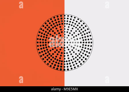 Metalloberfläche in orange und weiß lackiert. Schwarzer Kreis mit vielen kleinen Löchern in der Mitte perforiert. Industrielle Muster Stockfoto
