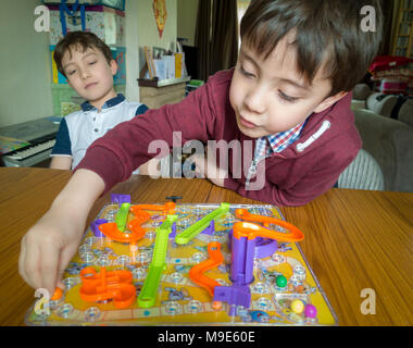 Zwei Jungen spielen eine Familie Brettspiel von Schlangen und Leitern Stockfoto