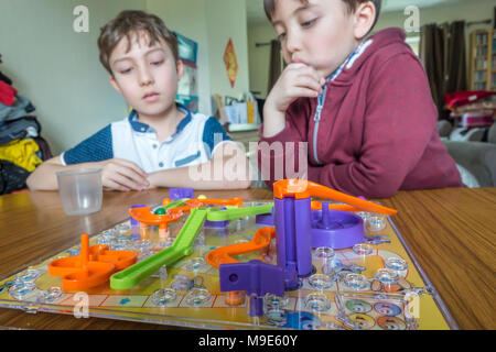 Zwei Jungen spielen eine Familie Brettspiel von Schlangen und Leitern Stockfoto