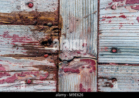 Brettern oder Platten mit Knoten und Baumstümpfe, geschälte rote Farbe, Risse und Nagelköpfe. Reich grunge, raue Textur Stockfoto