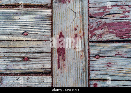 Brettern oder Platten mit Knoten und Baumstümpfe, geschälte rote Farbe, Risse und Nagelköpfe. Reich grunge, raue Textur Stockfoto