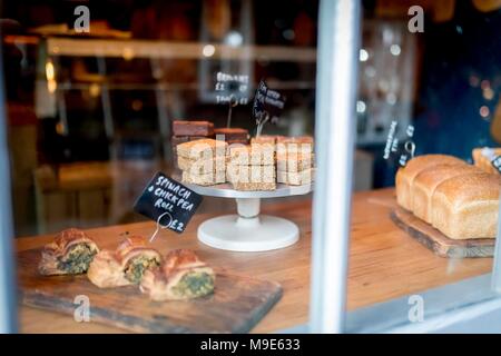 Flapjack und Kuchen Auswahl auf einem Display auf einem Kuchen stehen in einer Bäckerei Fenster in Großbritannien Stockfoto
