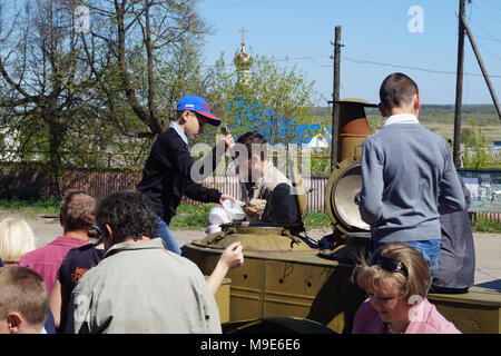 Mstyora, Russia-May 9,2014: Kinder werden Porridge und Kompott aus Feld Küche verteilen am Feiertag des Sieges am 9. Mai Stockfoto